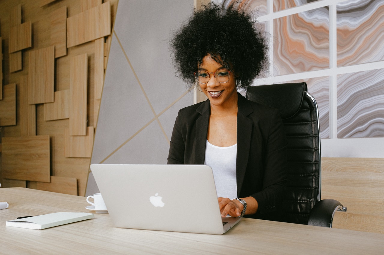 Business woman working on laptop smiling.