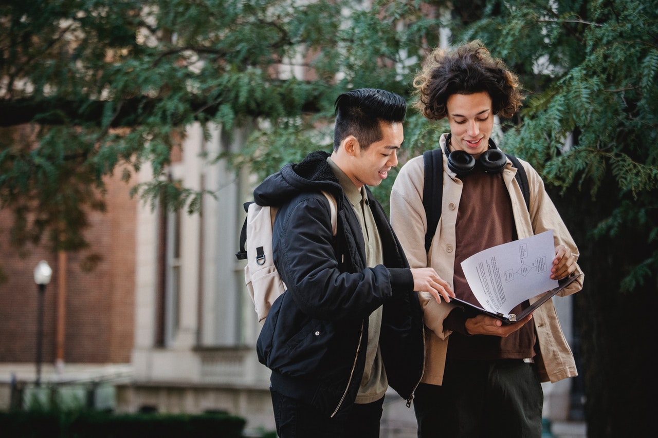 Two male college students looking at financial statements.