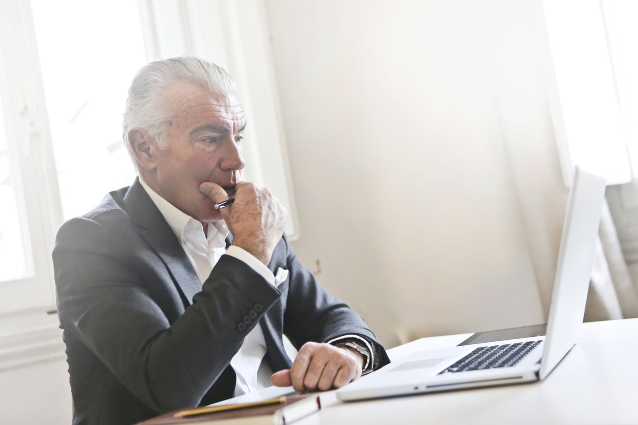 Older man looking at his financial statements online.