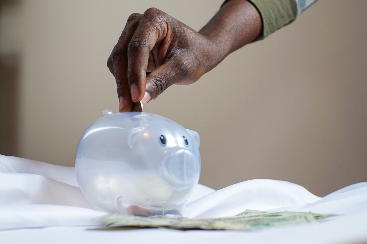 Man putting money into piggy bank.