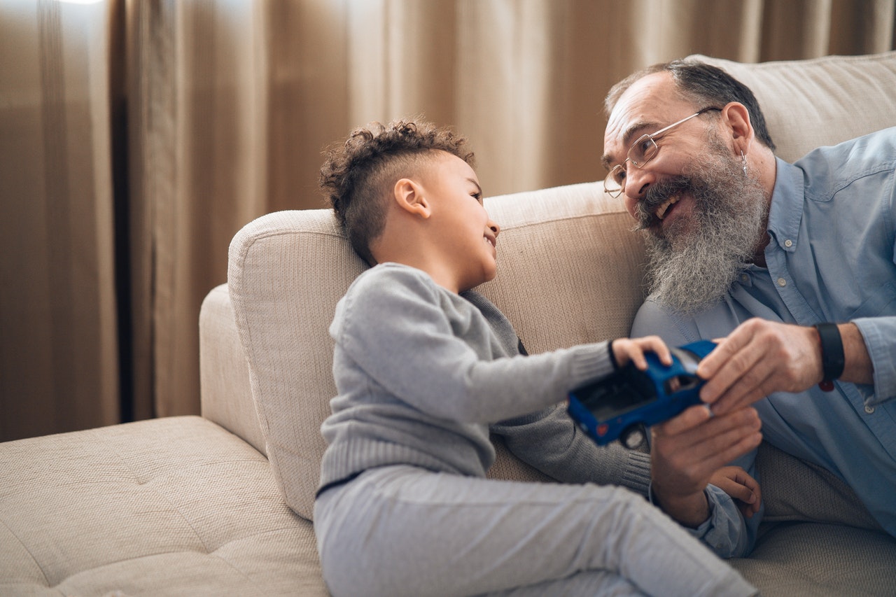 Grandfather playing with his grandson in living room.