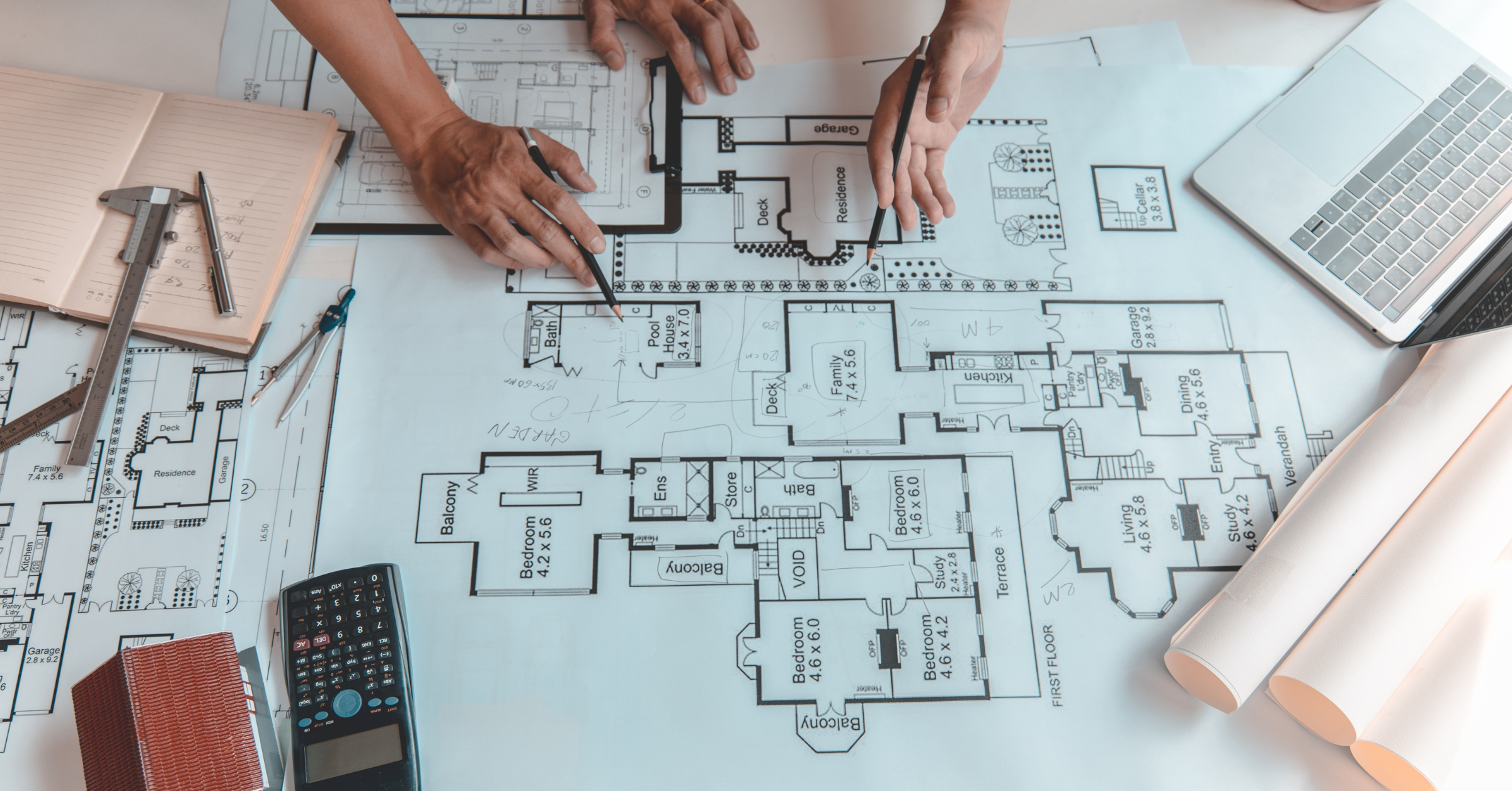 hands on a table with a blueprint, planning a house to depict a succession planning framework process